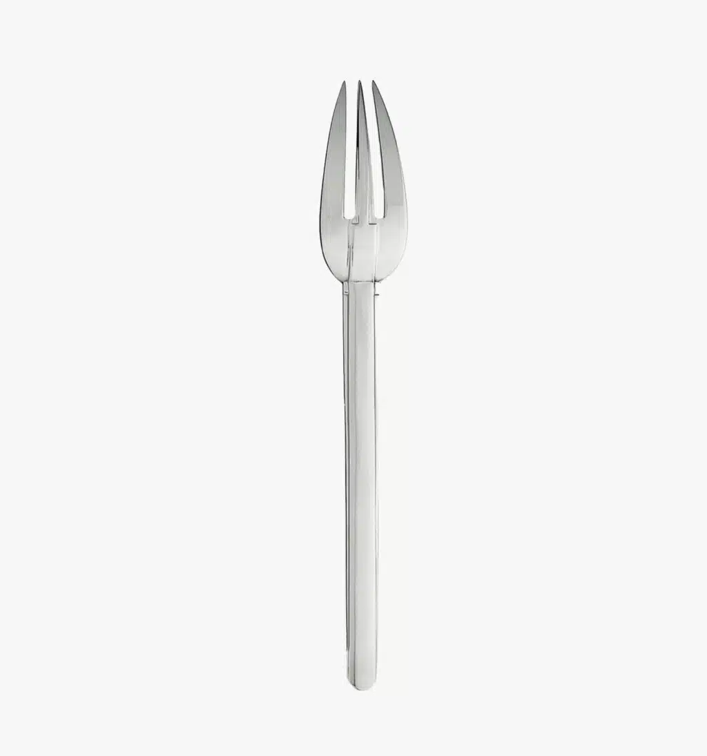 Serving fork in stainless steel from the Guéthary collection by Puiforcat on a light background.